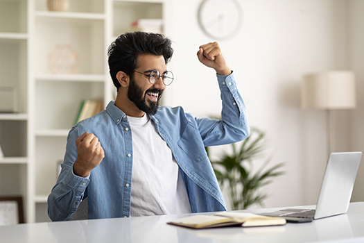 Overjoyed Indian Man Looking At Laptop Screen And Celebrating Success